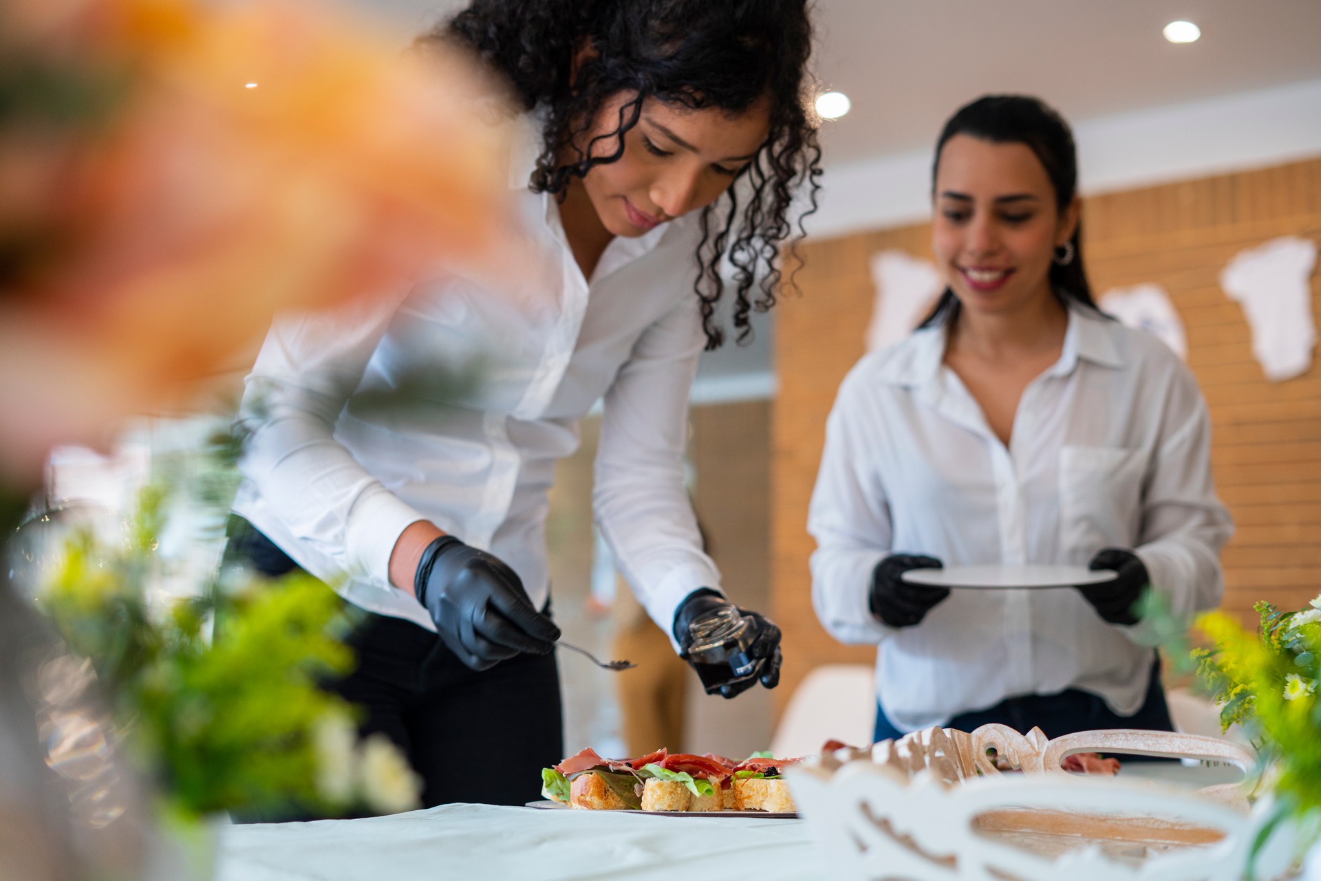 Women waitresses by profession are within the facilities of a Veneto organizing the decoration and food table